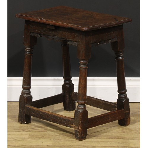 2003 - An 18th century oak joint stool, rounded rectangular seat, shaped apron, turned and blocked legs, 50... 