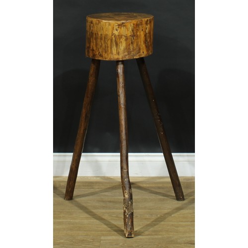 1987 - A primitive kitchen chopping block, of staked cricket table construction, 89cm high, the top 31cm di... 