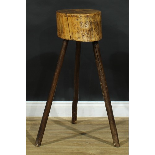 1987 - A primitive kitchen chopping block, of staked cricket table construction, 89cm high, the top 31cm di... 