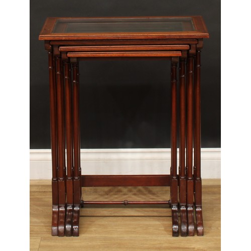 2373 - A set of Edwardian mahogany quartetto tables, each plateau with inset glass panel, outlined througho... 