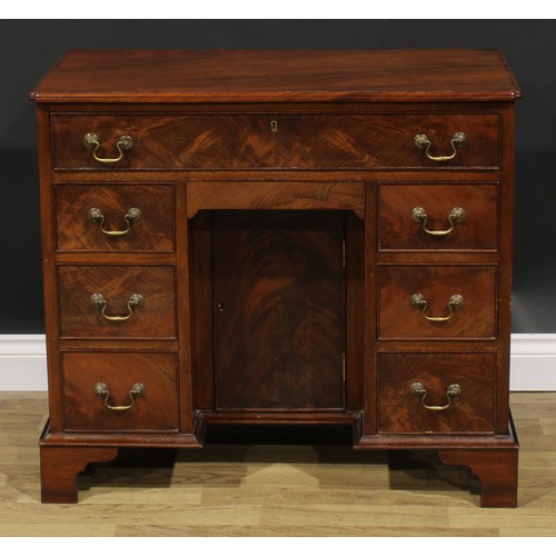 1740 - A George II Revival mahogany kneehole desk, rectangular top with reentrant foreangles above an arran... 