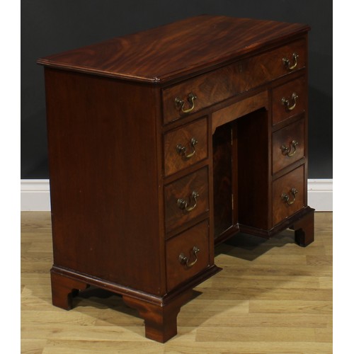 1740 - A George II Revival mahogany kneehole desk, rectangular top with reentrant foreangles above an arran... 