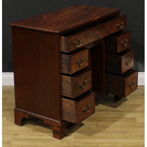 1740 - A George II Revival mahogany kneehole desk, rectangular top with reentrant foreangles above an arran... 