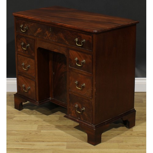 1740 - A George II Revival mahogany kneehole desk, rectangular top with reentrant foreangles above an arran... 