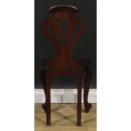 2535 - A pair of Victorian mahogany hall chairs, each with a pierced cartouche shaped back carved with a fl... 