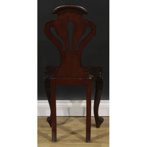 2535 - A pair of Victorian mahogany hall chairs, each with a pierced cartouche shaped back carved with a fl... 