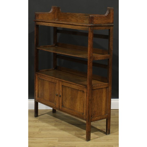 2328 - An Arts & Crafts oak bookcase, three-quarter gallery above open shelves and a pair of panel doors, s... 