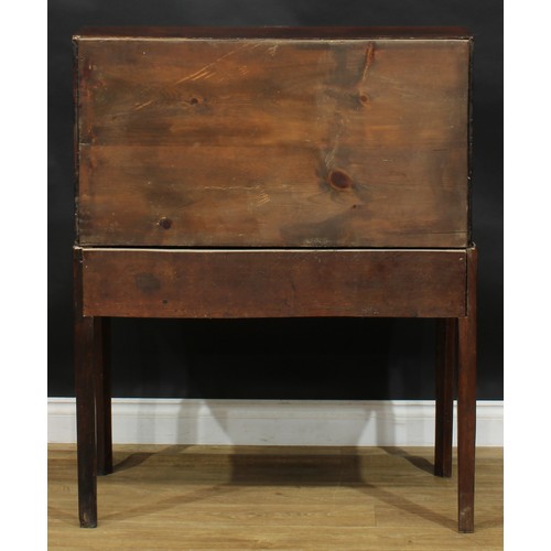 2041 - A George III vernacular oak bureau on stand, fall front enclosing small drawers and pigeonholes abov... 