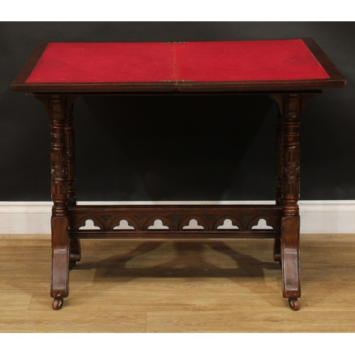 2592 - A Victorian Neo-Gothic oak card table, hinged top enclosing a baize lined playing surface above a de... 