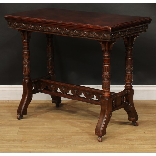 2592 - A Victorian Neo-Gothic oak card table, hinged top enclosing a baize lined playing surface above a de... 