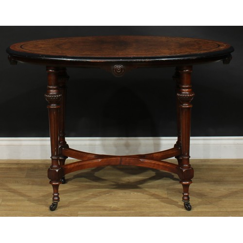 2576 - A Victorian Aesthetic Movement amboyna banded walnut and parcel-ebonised centre table, oval top, flu... 