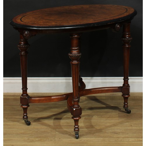 2576 - A Victorian Aesthetic Movement amboyna banded walnut and parcel-ebonised centre table, oval top, flu... 