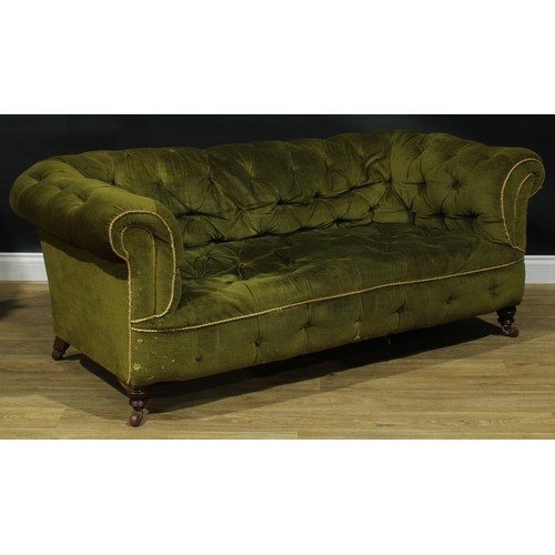 2256 - A Victorian Chesterfield sofa, stuffed-over deep-button upholstery, turned legs, ceramic casters, on... 