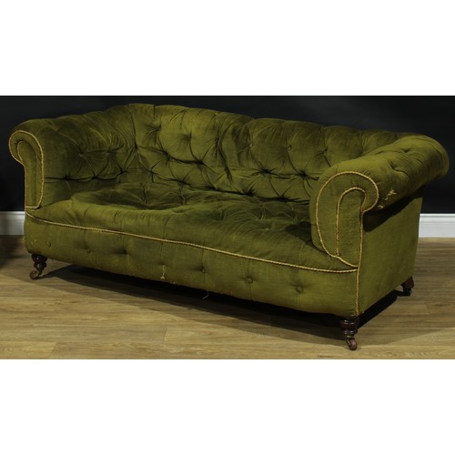 2256 - A Victorian Chesterfield sofa, stuffed-over deep-button upholstery, turned legs, ceramic casters, on... 