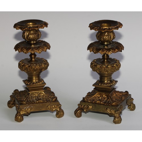 1818 - A pair of 19th century gilt bronze candlesticks, cast throughout with scrolling acanthus, 21cm high,... 