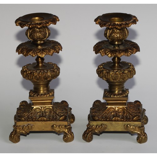 1818 - A pair of 19th century gilt bronze candlesticks, cast throughout with scrolling acanthus, 21cm high,... 