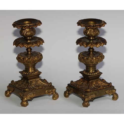 1818 - A pair of 19th century gilt bronze candlesticks, cast throughout with scrolling acanthus, 21cm high,... 