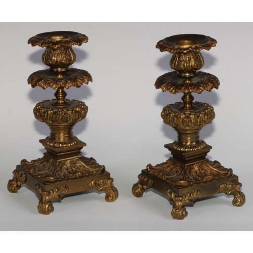 1818 - A pair of 19th century gilt bronze candlesticks, cast throughout with scrolling acanthus, 21cm high,... 