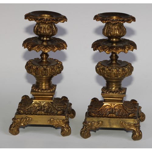 1818 - A pair of 19th century gilt bronze candlesticks, cast throughout with scrolling acanthus, 21cm high,... 