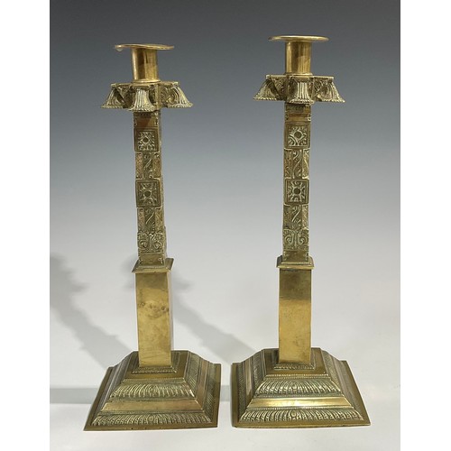 2089 - A pair of large 19th century Indian gilt brass candlesticks, cast and chased with stylised lotus and... 