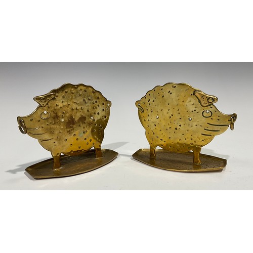 2086 - A pair of German Arts and Crafts brass models, of stylised pigs, in silhouette, planished overall, 1... 