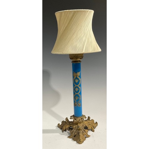 2667 - An early 20th century gilt metal and blue glass table lamp, the cylindrical pillar decorated in gilt... 