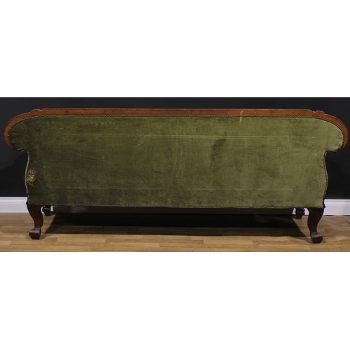 2588 - A Victorian mahogany sofa, the cresting rail carved with flowers and leaves, stuffed-over upholstery... 