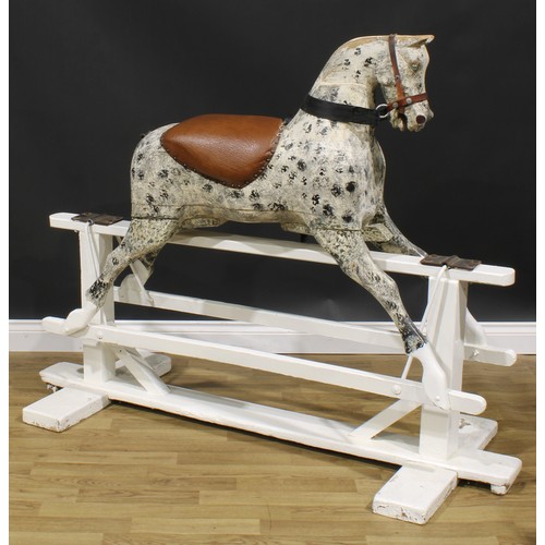 2336 - An early 20th century carved softwood dapple rocking horse, trestle base, 125cm high, 154cm long