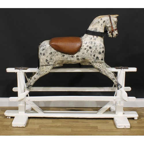 2336 - An early 20th century carved softwood dapple rocking horse, trestle base, 125cm high, 154cm long