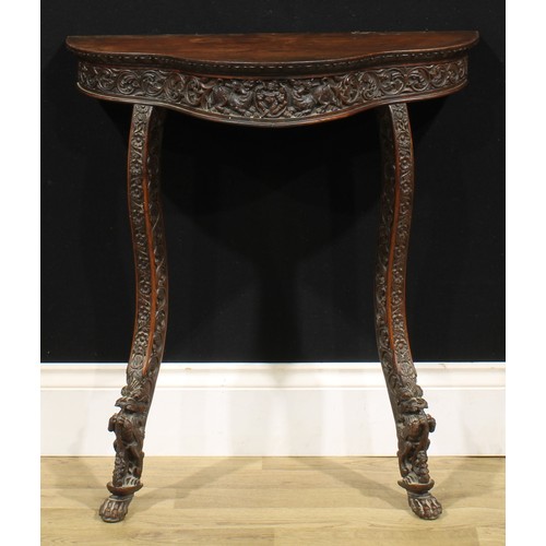 1580 - A 19th century Burmese hardwood serpentine console table, slightly oversailing top above a deep frie... 