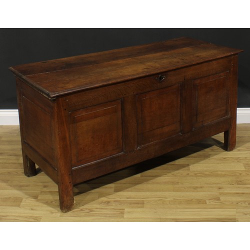 2664 - An early 18th century oak blanket chest, hinged top enclosing a till, above three raised and fielded... 