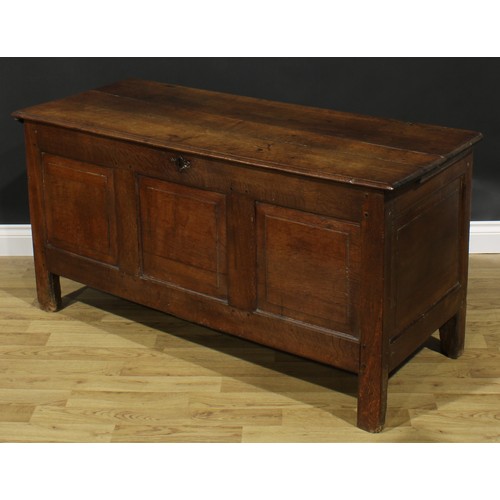 2664 - An early 18th century oak blanket chest, hinged top enclosing a till, above three raised and fielded... 