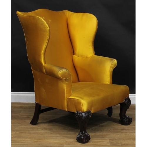 2102 - A George II Revival mahogany wing armchair, stuffed-over upholstery, cabriole forelegs carved to the... 