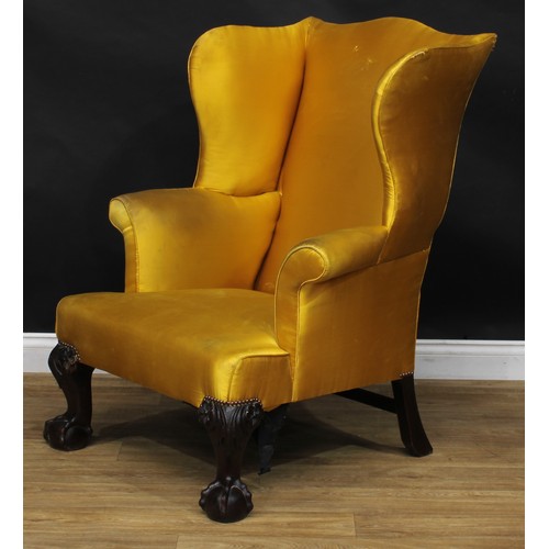 2102 - A George II Revival mahogany wing armchair, stuffed-over upholstery, cabriole forelegs carved to the... 