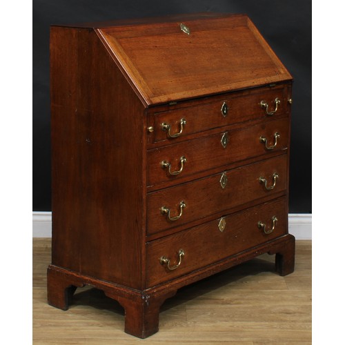 1941 - A George III oak bureau, fall front enclosing a small door, small drawers and pigeonholes, above fou... 