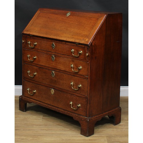 1941 - A George III oak bureau, fall front enclosing a small door, small drawers and pigeonholes, above fou... 