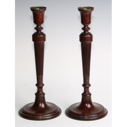 1822 - A pair of Adam Revival mahogany table candlesticks, bell shaped sconces with brass nozzles, tapered ... 