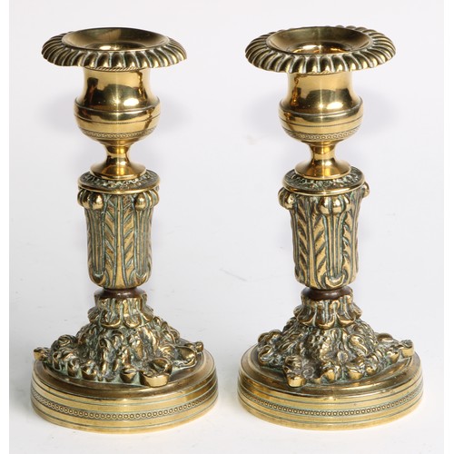 2092 - A pair of Regency bronze candlesticks, campana sconces with fluted nozzles, acanthus cast pillars, c... 