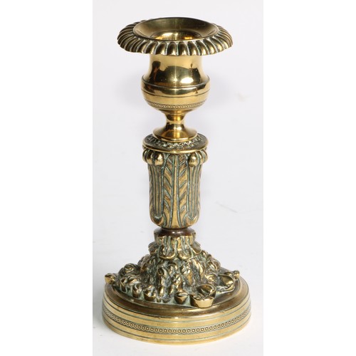 2092 - A pair of Regency bronze candlesticks, campana sconces with fluted nozzles, acanthus cast pillars, c... 