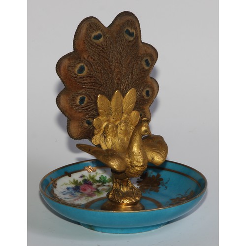 2452 - A French Palais Royal gilt bronze and porcelain pin cushion, as a peacock, embroidered tail, the dis... 