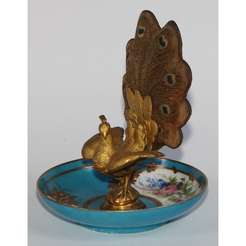 2452 - A French Palais Royal gilt bronze and porcelain pin cushion, as a peacock, embroidered tail, the dis... 