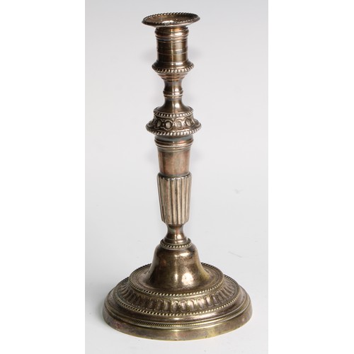 1809 - A pair of 18th century French brass table candlesticks, of seamed construction, tapered pillars, flu... 