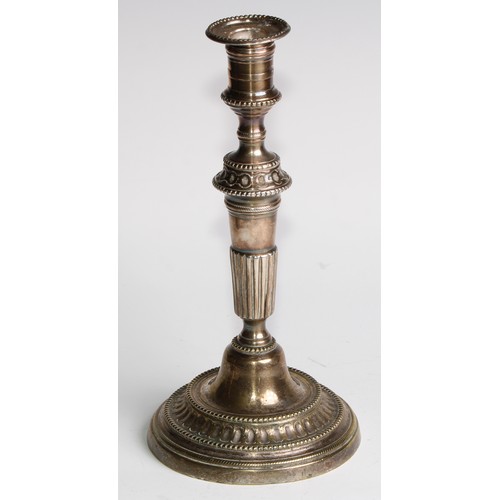 1809 - A pair of 18th century French brass table candlesticks, of seamed construction, tapered pillars, flu... 