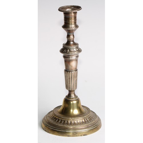 1809 - A pair of 18th century French brass table candlesticks, of seamed construction, tapered pillars, flu... 