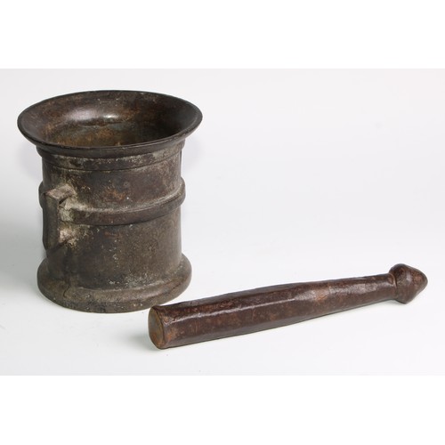 1679 - A cast iron pestle and mortar, flared rim above a quarter girdle, angular lug handles, skirted base,... 