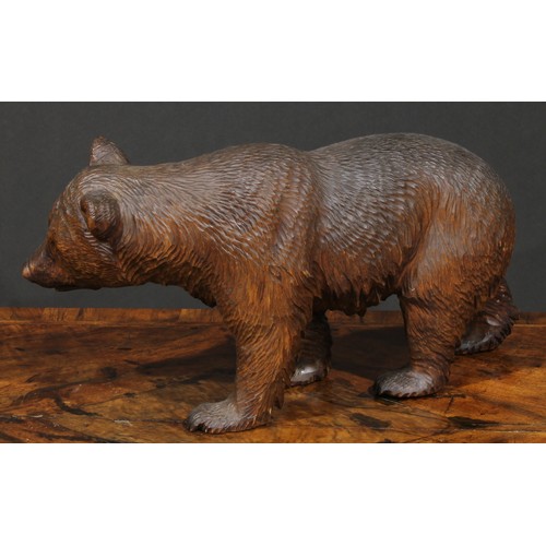 2501 - A large Black Forest bear, naturalistically carved, on all fours, glass eyes, painted mouth, 36cm lo... 