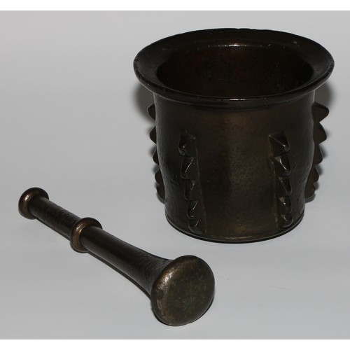 1551 - A 17th/18th century Islamic bronze pestle and mortar, flared rim, the side with geometric lugs, poss... 