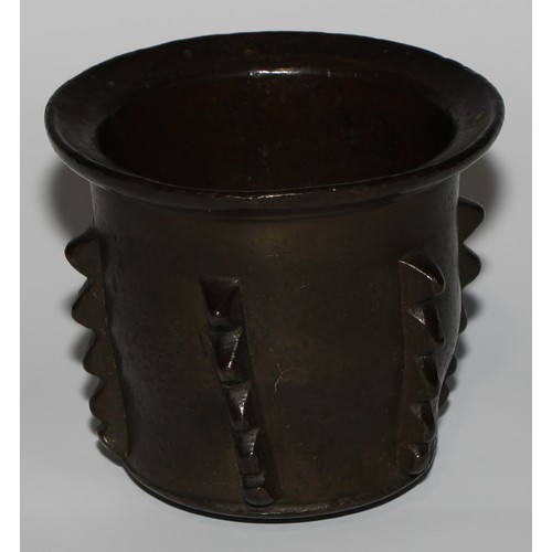 1551 - A 17th/18th century Islamic bronze pestle and mortar, flared rim, the side with geometric lugs, poss... 