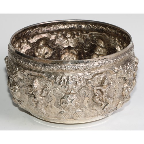 859 - A Burmese silver circular bowl, repousse chased with figures, deities and lotus, 21cm diam, c.1880, ... 