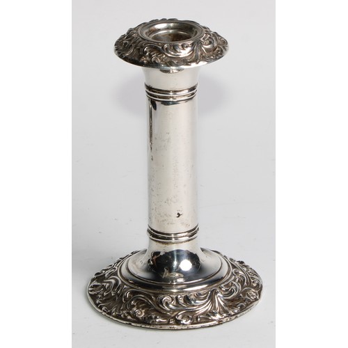 1016 - A pair of Edwardian silver candlesticks, leafy scroll borders, 16cm high, Birmingham 1906